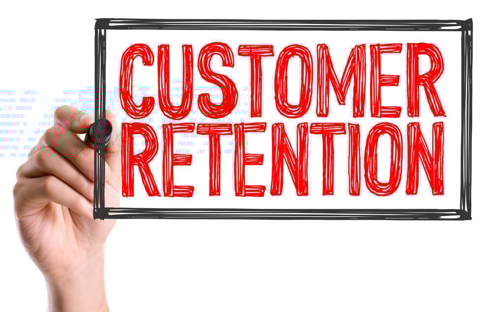 Hand with marker writing the text Customer Retention